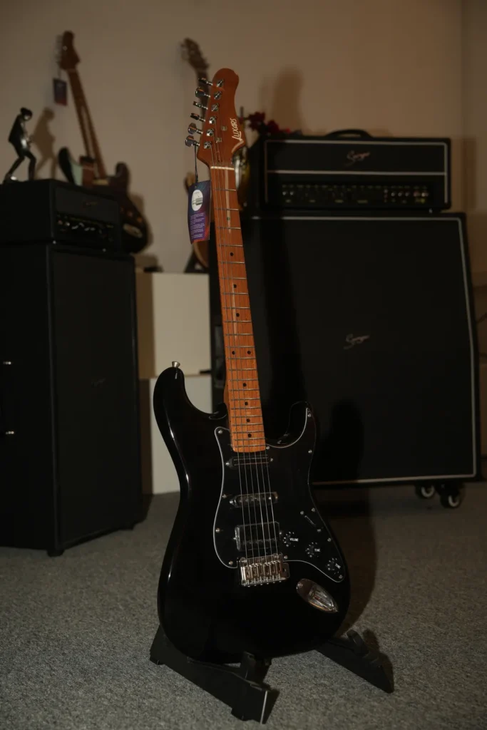 Real photograph of a black electric guitar on a stand